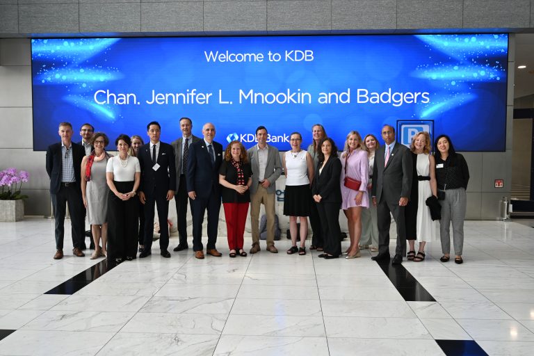Members of the delegation in front of a sign that says Welcom to KDB Chan. Jennifer L. Mnookin and Badgers